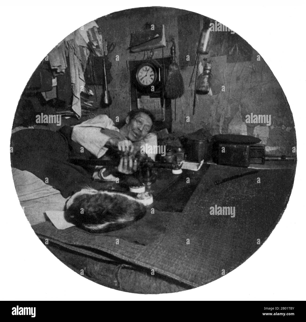 USA: Man smoking in an opium den. San Francisco Chinatown, c. 1895.  San Francisco's Chinatown was the port of entry for early Hoisanese and Zhongshanese Chinese immigrants from the Guangdong province of southern China from the 1850s to the 1900s. The area was the one geographical region deeded by the city government and private property owners which allowed Chinese persons to inherit and inhabit dwellings within the city.  The majority of these Chinese shopkeepers, restaurant owners, and hired workers in San Francisco Chinatown were predominantly Hoisanese and male. Stock Photo