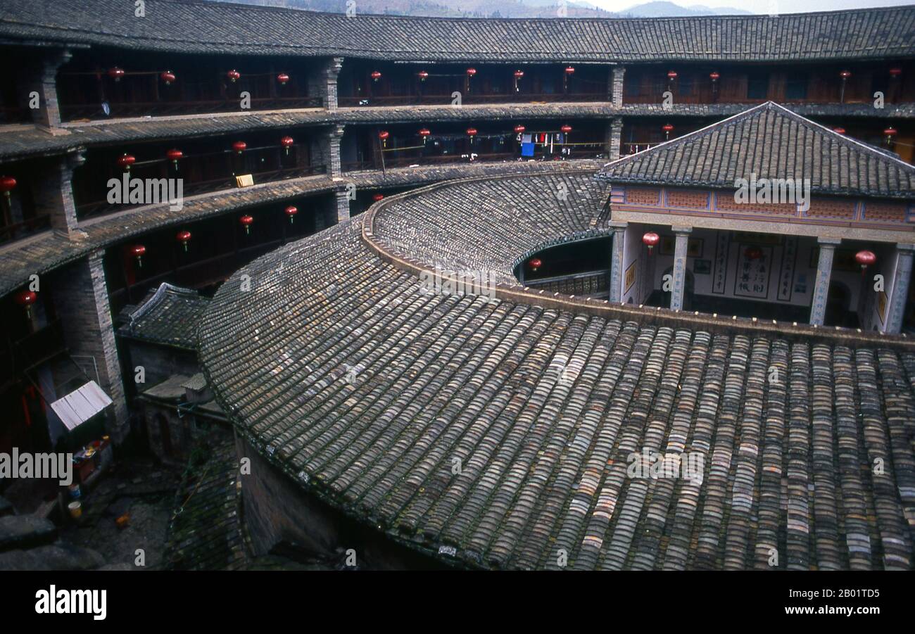 China: The inner courtyard at Zhenchang Lou Hakka Tower near Hukeng, Yongding County, Fujian Province.  The Hakka (Kejia in Mandarin; literally 'guest people') are Han Chinese who speak the Hakka language. Their distinctive earthen houses or tulou can be found in the borderland counties where Guangdong, Jiangxi and Fujian provinces meet.  Communal entities, tulou are fortified against marauding bandits and generally made of compacted earth, bamboo, wood and stone. They contain many rooms on several storeys, so that several families can live together. Stock Photo