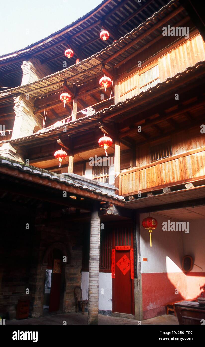 China: The inner courtyard at Zhenchang Lou Hakka Tower near Hukeng, Yongding County, Fujian Province.  The Hakka (Kejia in Mandarin; literally 'guest people') are Han Chinese who speak the Hakka language. Their distinctive earthen houses or tulou can be found in the borderland counties where Guangdong, Jiangxi and Fujian provinces meet.  Communal entities, tulou are fortified against marauding bandits and generally made of compacted earth, bamboo, wood and stone. They contain many rooms on several storeys, so that several families can live together. Stock Photo