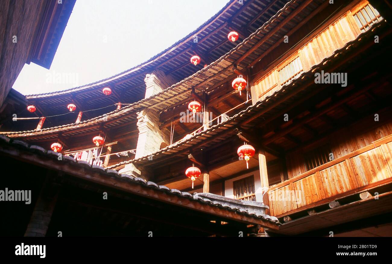 China: The inner courtyard at Zhenchang Lou Hakka Tower near Hukeng, Yongding County, Fujian Province.  The Hakka (Kejia in Mandarin; literally 'guest people') are Han Chinese who speak the Hakka language. Their distinctive earthen houses or tulou can be found in the borderland counties where Guangdong, Jiangxi and Fujian provinces meet.  Communal entities, tulou are fortified against marauding bandits and generally made of compacted earth, bamboo, wood and stone. They contain many rooms on several storeys, so that several families can live together. Stock Photo