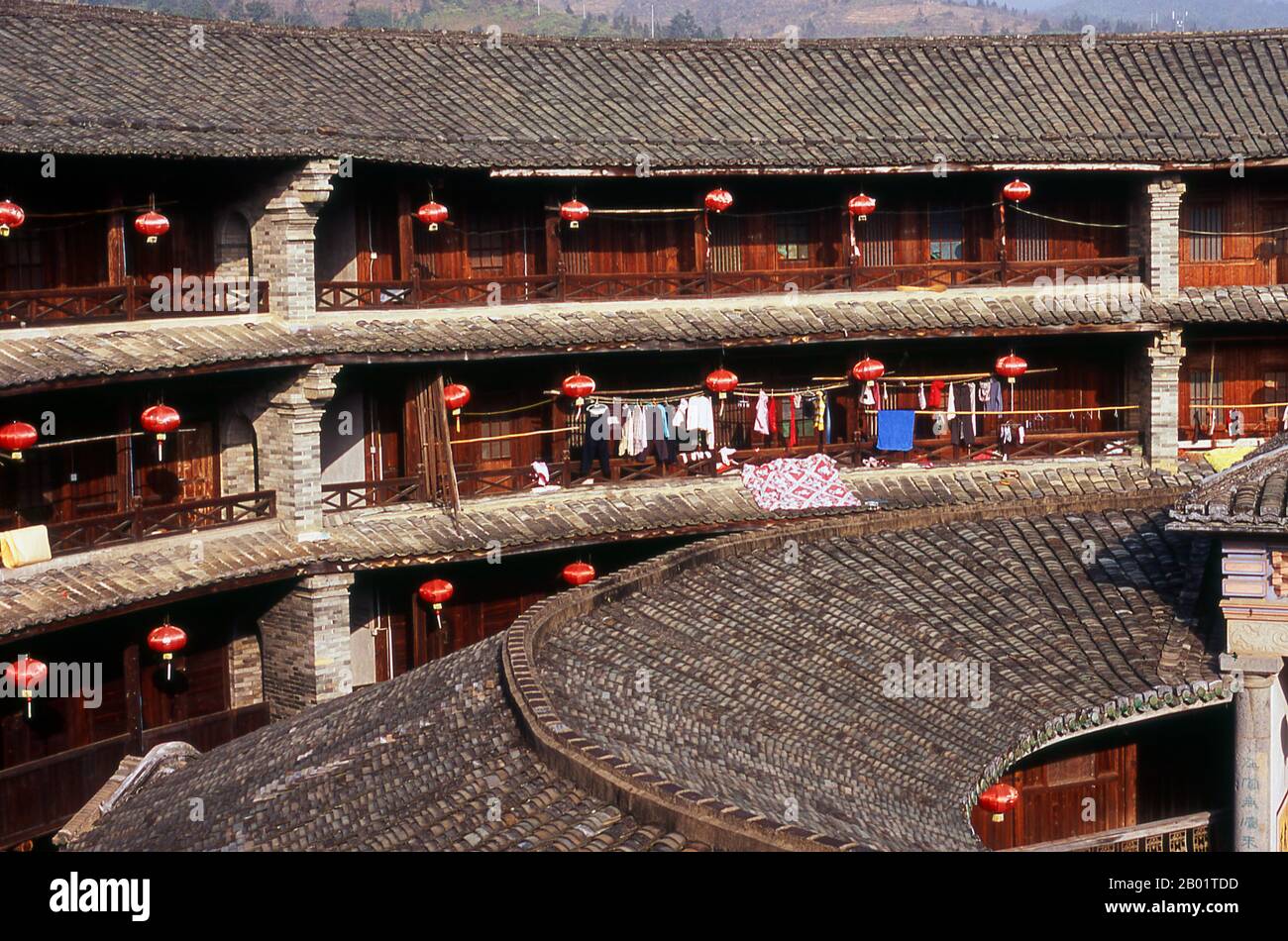 China: The inner courtyard at Zhenchang Lou Hakka Tower near Hukeng, Yongding County, Fujian Province.  The Hakka (Kejia in Mandarin; literally 'guest people') are Han Chinese who speak the Hakka language. Their distinctive earthen houses or tulou can be found in the borderland counties where Guangdong, Jiangxi and Fujian provinces meet.  Communal entities, tulou are fortified against marauding bandits and generally made of compacted earth, bamboo, wood and stone. They contain many rooms on several storeys, so that several families can live together. Stock Photo