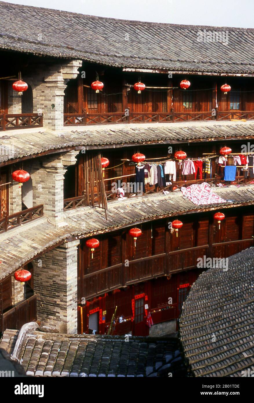 China: The inner courtyard at Zhenchang Lou Hakka Tower near Hukeng, Yongding County, Fujian Province.  The Hakka (Kejia in Mandarin; literally 'guest people') are Han Chinese who speak the Hakka language. Their distinctive earthen houses or tulou can be found in the borderland counties where Guangdong, Jiangxi and Fujian provinces meet.  Communal entities, tulou are fortified against marauding bandits and generally made of compacted earth, bamboo, wood and stone. They contain many rooms on several storeys, so that several families can live together. Stock Photo