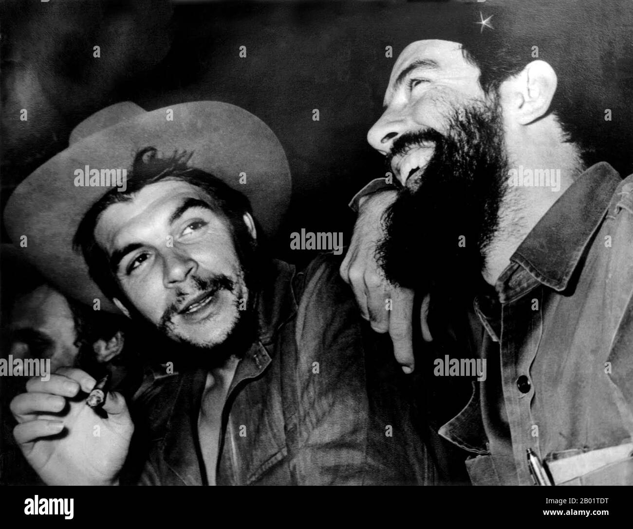 Cuba: Che Guevara (centre) talks with Camilo Cienfuegos (right), Fidel Castro just visible to left, c. 1959.  The Cuban Revolution was a successful armed revolt by Fidel Castro's 26th of July Movement, which overthrew the US-backed Cuban dictator Fulgencio Batista on 1 January 1959, after over five years of struggle. Stock Photo