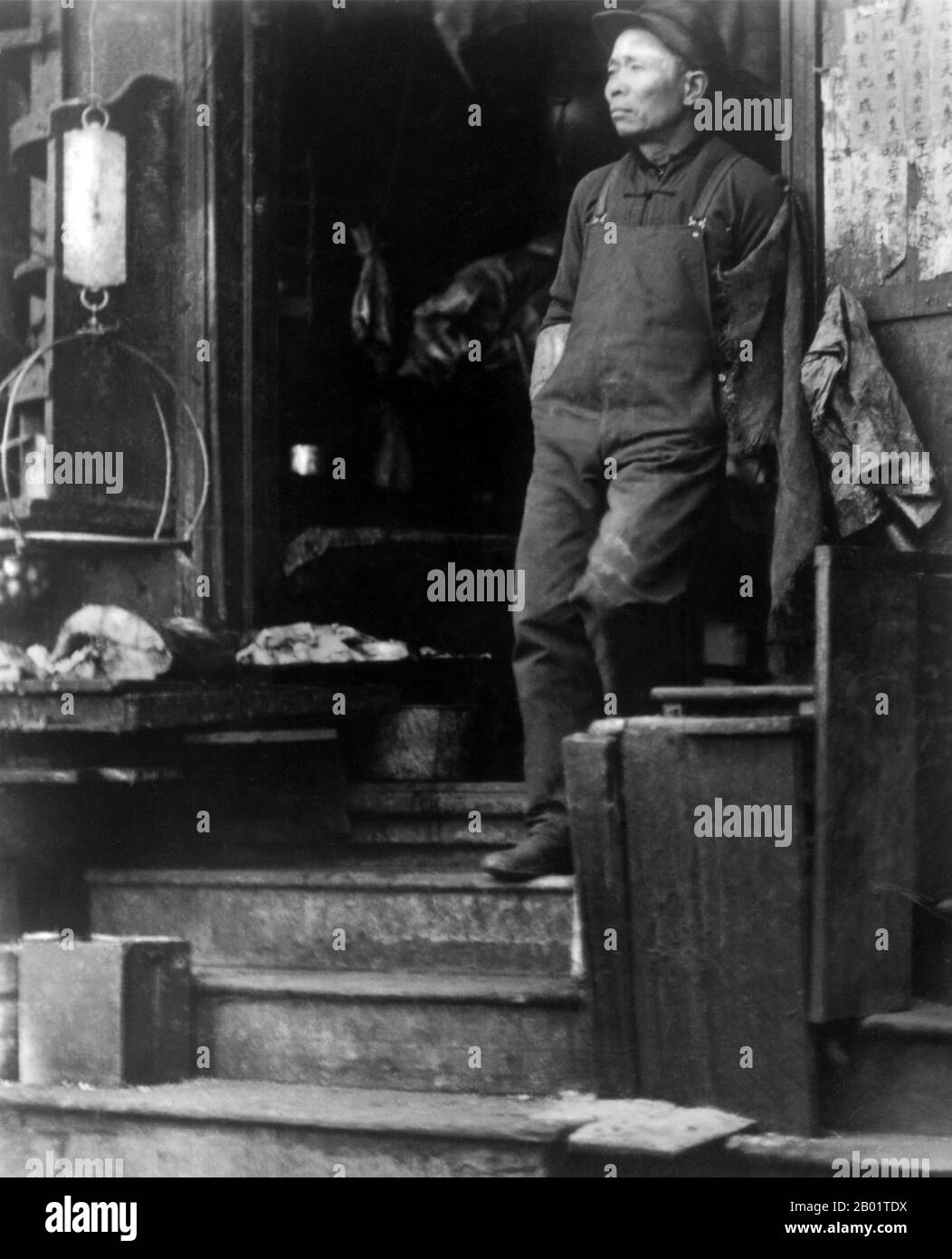 USA: Fish market; clerk standing on stairs, San Francisco Chinatown. Photo by D.H. Wulzen, c. 1900.  San Francisco's Chinatown was the port of entry for early Hoisanese and Zhongshanese Chinese immigrants from the Guangdong province of southern China from the 1850s to the 1900s. The area was the one geographical region deeded by the city government and private property owners which allowed Chinese persons to inherit and inhabit dwellings within the city.  The majority of these Chinese shopkeepers, restaurant owners and hired workers in San Francisco were mainly Hoisanese and male. Stock Photo