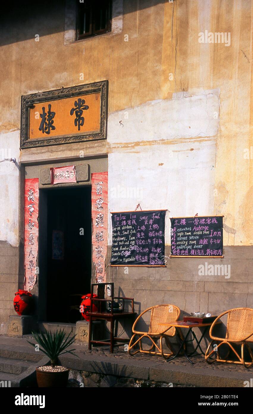 China: Restaurant at the Fuyu Lou Hakka Tower near Hukeng (now the Fuyulou Changdi Earth Building Hostel), Yongding County, Fujian Province.  The Hakka (Kejia in Mandarin; literally 'guest people') are Han Chinese who speak the Hakka language. Their distinctive earthen houses or tulou can be found in the borderland counties where Guangdong, Jiangxi and Fujian provinces meet.  Communal entities, tulou are fortified against marauding bandits and generally made of compacted earth, bamboo, wood and stone. They contain many rooms on several storeys, so that several families can live together. Stock Photo