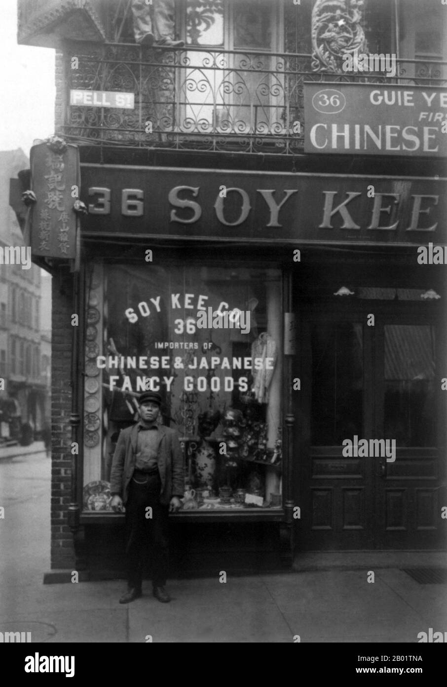 USA: Chinese man standing outside 36 Pell Street, New York Chinatown, 1903.  Manhattan's Chinatown, home to the largest enclave of Chinese people in the Western hemisphere, is located in the borough of Manhattan in New York City. Manhattan's Chinatown is one of the oldest ethnic Chinese enclaves outside of Asia.  Until the 1960s, the majority of the Chinese population in Chinatown emigrated from Guangdong province and Hong Kong, thus they were native speakers of Cantonese, especially the Canton and Taishan dialects. A minority of Hakka was also represented. Stock Photo