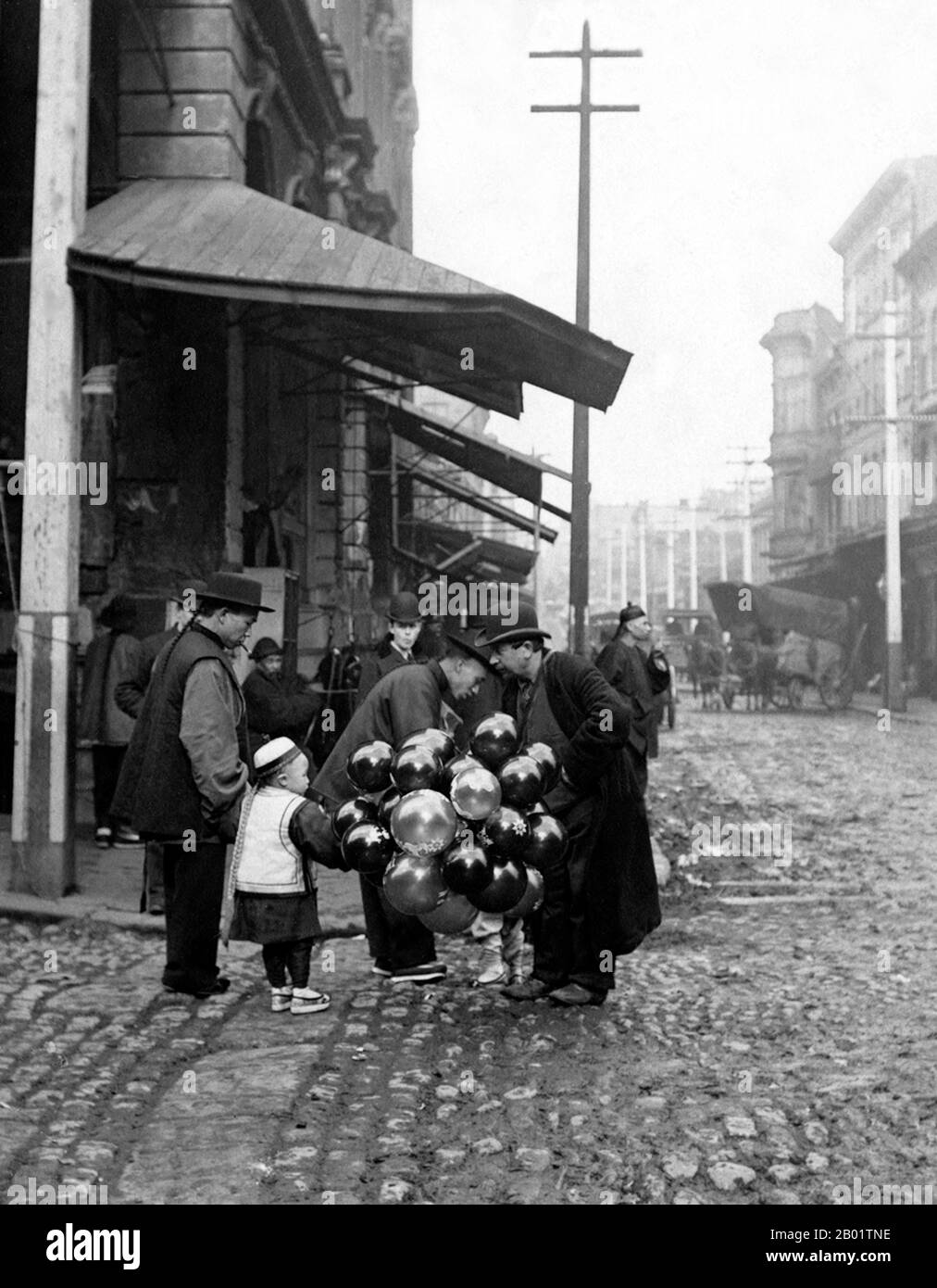 USA: Jewish man selling balloons, Oakland Chinatown. Photo by Arnold Genthe (1869-1942), early 20th century.  Oakland Chinatown dates back to the arrival of Chinese immigrants in the 1850s, making it one of the oldest Chinatowns in North America. By 1860, the census of Oakland included 96 'Asiatics' among a total of 1,543. More Chinese arrived to help build the Central Pacific Railroad western portion of the First Transcontinental Railroad during the Coolie slave trade during the 1860s.  The Chinese settled in shrimp camps on the estuary of Oakland at 1st Street and Castro in the 1850s. Stock Photo