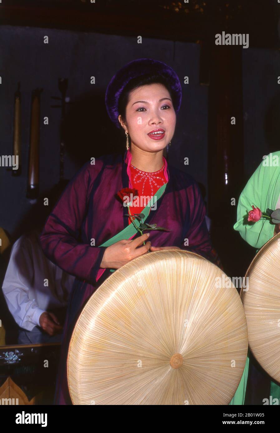Vietnam: Singer with a traditional Vietnamese orchestra at Van Mieu (the Temple of Literature), Hanoi.  Vietnam has a long tradition of music and theatre that combines indigenous and foreign influences. The earliest known instruments are the frog drums of the Dong Son Period from around 250BC. This was followed by a millennium of immersion in Chinese cultural traditions which remains very apparent.  In 981, after the reassertion of national independence, King Le Dai Hanh invaded neighbouring Champa and carried the royal court dancers and musicians back to his capital. Stock Photo