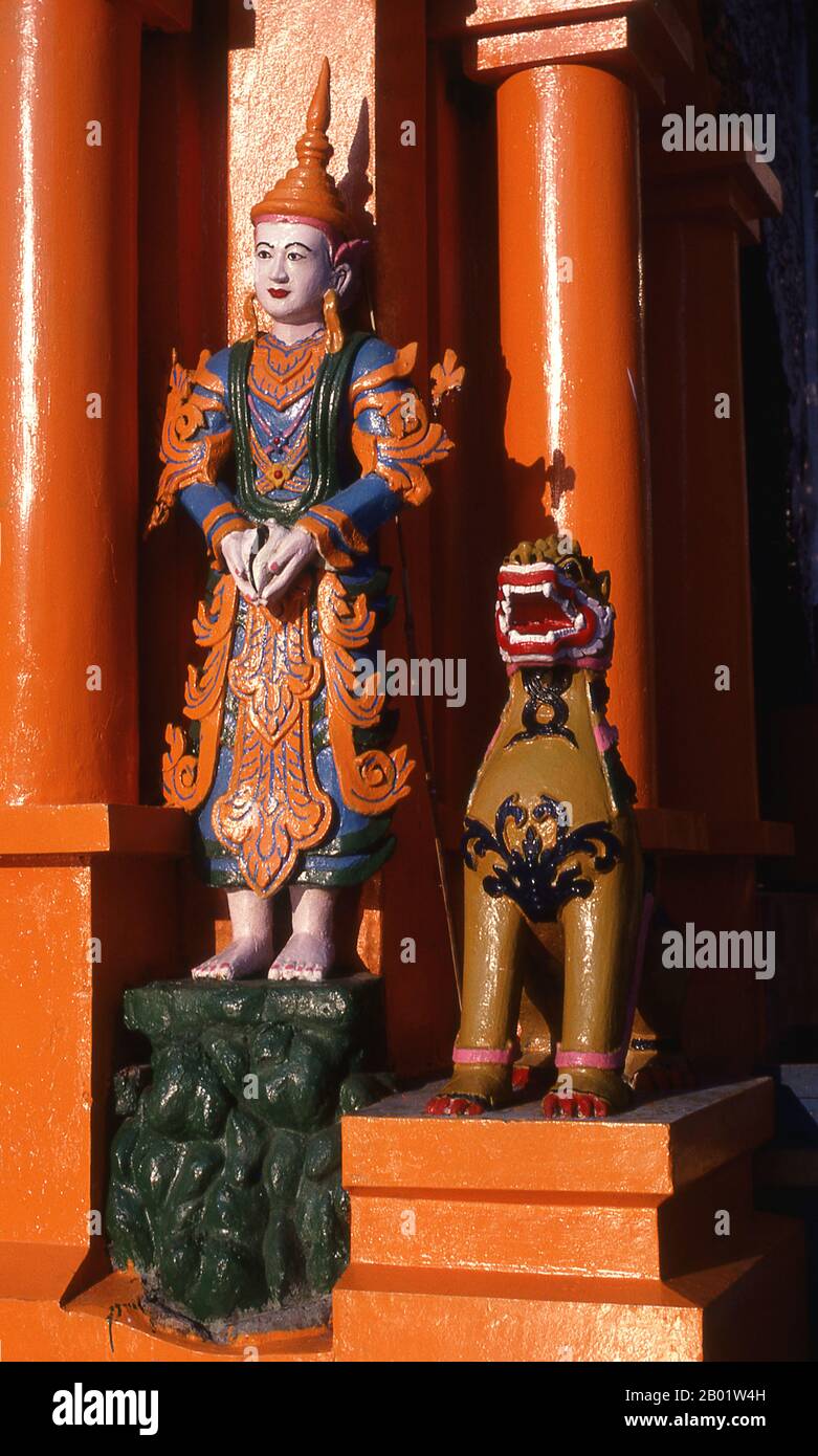 Burma/Myanmar: Figures at the door of the Temple of the Konagamana Buddha, Shwedagon Pagoda, Yangon (Rangoon).  The golden stupa of the Shwedagon Pagoda rises almost 100 m (330ft) above its setting on Singuttara Hill and is plated with 8,688 solid-gold slabs. This central stupa is surrounded by more than 100 other buildings, including smaller stupas and pavilions.  The pagoda was already well established when Bagan dominated Burma in the 11th century. Queen Shinsawbu, who ruled in the 15th century, is believed to have given the pagoda its present shape. Stock Photo