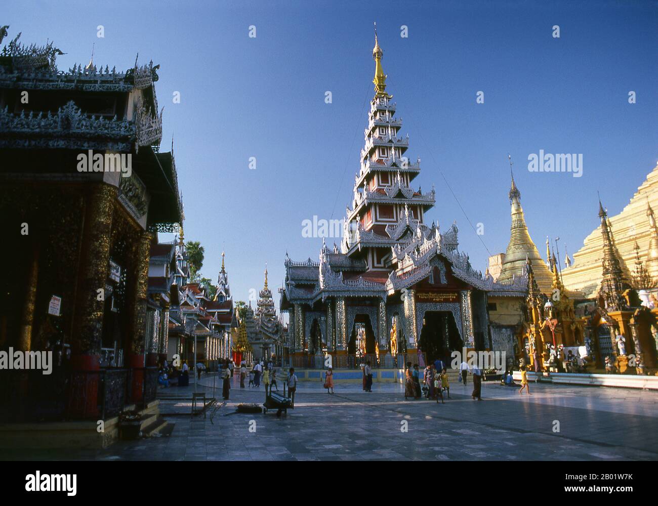 Burma/Myanmar: Inside the Shwedagon Pagoda complex, Yangon (Rangoon).  The golden stupa of the Shwedagon Pagoda rises almost 100 m (330ft) above its setting on Singuttara Hill and is plated with 8,688 solid-gold slabs. This central stupa is surrounded by more than 100 other buildings, including smaller stupas and pavilions.  The pagoda was already well established when Bagan dominated Burma in the 11th century. Queen Shinsawbu, who ruled in the 15th century, is believed to have given the pagoda its present shape. She also built the terraces and walls around the stupa. Stock Photo