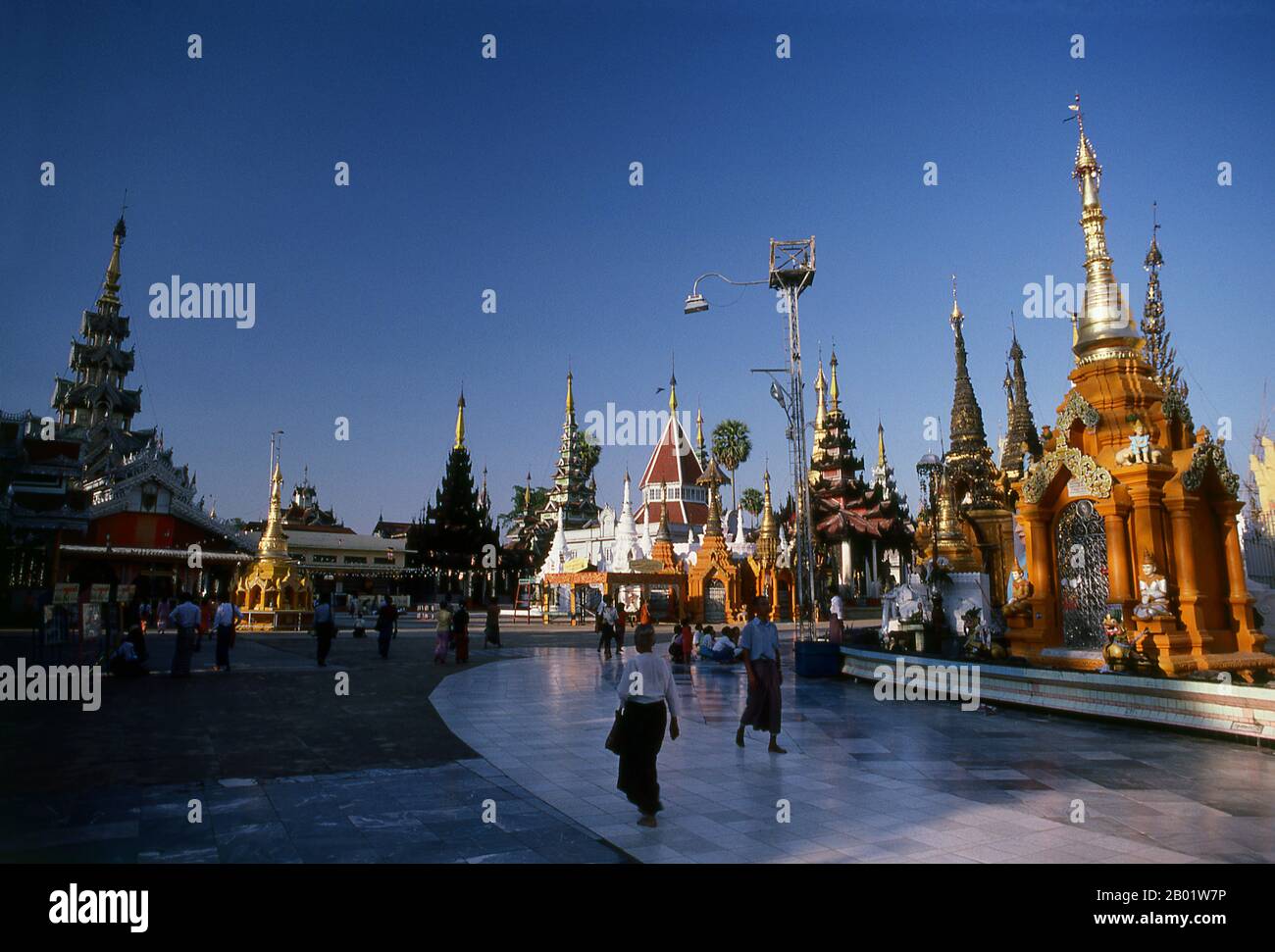 Burma/Myanmar: Inside the Shwedagon Pagoda complex, Yangon (Rangoon).  The golden stupa of the Shwedagon Pagoda rises almost 100 m (330ft) above its setting on Singuttara Hill and is plated with 8,688 solid-gold slabs. This central stupa is surrounded by more than 100 other buildings, including smaller stupas and pavilions.  The pagoda was already well established when Bagan dominated Burma in the 11th century. Queen Shinsawbu, who ruled in the 15th century, is believed to have given the pagoda its present shape. She also built the terraces and walls around the stupa. Stock Photo