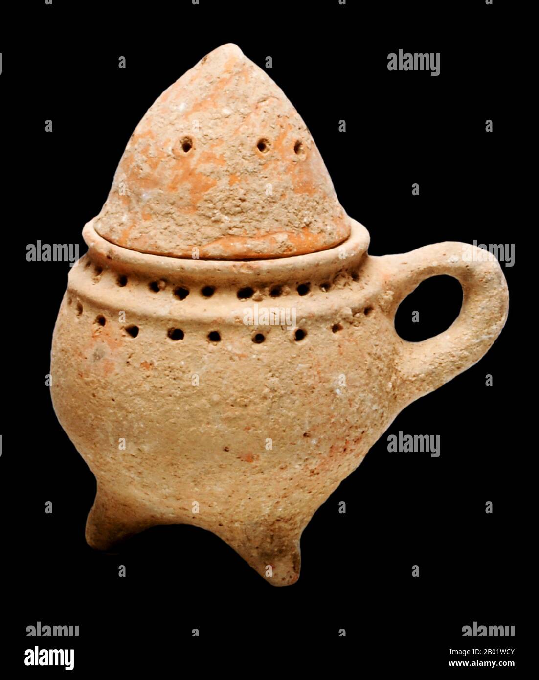 Palestine/Israel: Terracotta incense burner with lid. Iron Age period, 8th century BCE.  Incense is composed of aromatic plant materials, often combined with essential oils. The forms taken by incense differ with the underlying culture, and have changed with advances in technology and increasing diversity in the reasons for burning it.  Incense can generally be separated into two main types: 'indirect-burning' and 'direct-burning.' Indirect-burning incense (or 'non-combustible incense') is not capable of burning on its own, and requires a separate heat source. Stock Photo