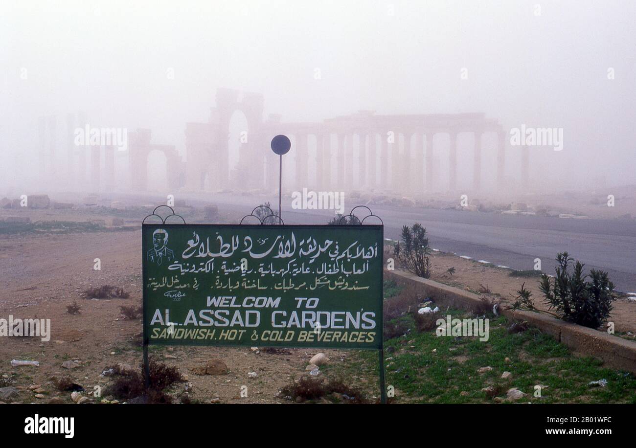 Syria: The ruins of ancient Palmyra appear through the early morning mist.  Palmyra was an ancient city in Syria. It was an important city in central Syria, located in an oasis 215 km northeast of Damascus and 180 km southwest of the Euphrates at Deir ez-Zor. It had long been a vital caravan city for travellers crossing the Syrian desert and was known as the Bride of the Desert. The earliest documented reference to the city by its Semitic name Tadmor, Tadmur or Tudmur (which means 'the town that repels' in Amorite and 'the indomitable town' in Aramaic) is recorded in Babylonian tablets. Stock Photo