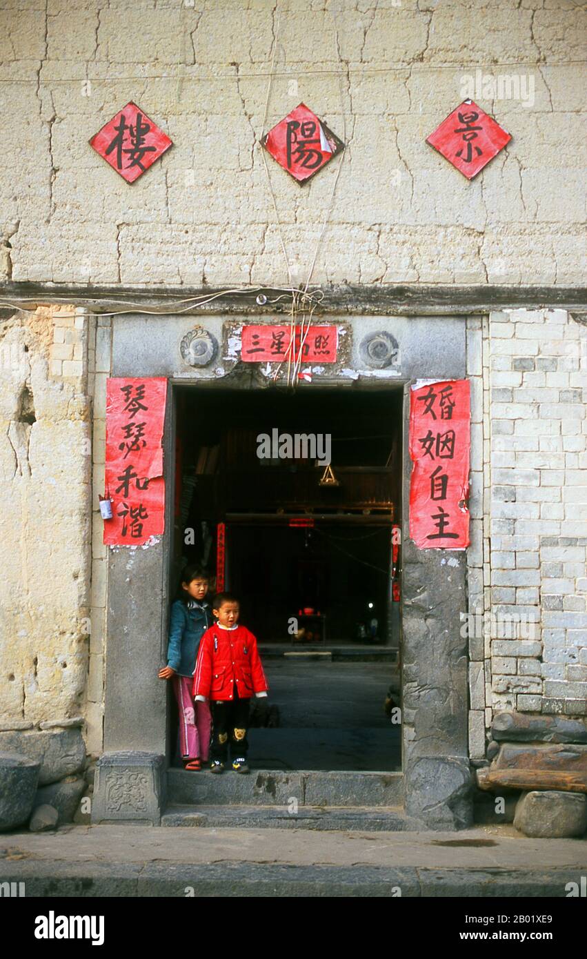 The Hakka (Kejia in Mandarin; literally 'guest people') are Han Chinese who speak the Hakka language. Their distinctive earthen houses or tulou can be found in the borderland counties where Guangdong, Jiangxi and Fujian provinces meet.  Communal entities, tulou are fortified against marauding bandits and generally made of compacted earth, bamboo, wood and stone. They contain many rooms on several storeys, so that several families can live together. The small, self-contained design is a common characteristic of Hakka dwellings (eg the Hakka walled villages at Kam Tin in Hong Kong’s New Territor Stock Photo