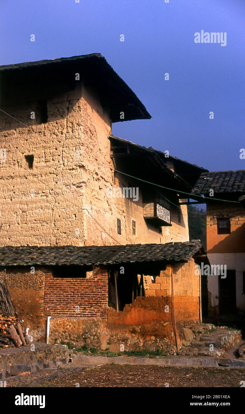 The Hakka (Kejia in Mandarin; literally 'guest people') are Han Chinese who speak the Hakka language. Their distinctive earthen houses or tulou can be found in the borderland counties where Guangdong, Jiangxi and Fujian provinces meet.  Communal entities, tulou are fortified against marauding bandits and generally made of compacted earth, bamboo, wood and stone. They contain many rooms on several storeys, so that several families can live together. The small, self-contained design is a common characteristic of Hakka dwellings (eg the Hakka walled villages at Kam Tin in Hong Kong’s New Territor Stock Photo