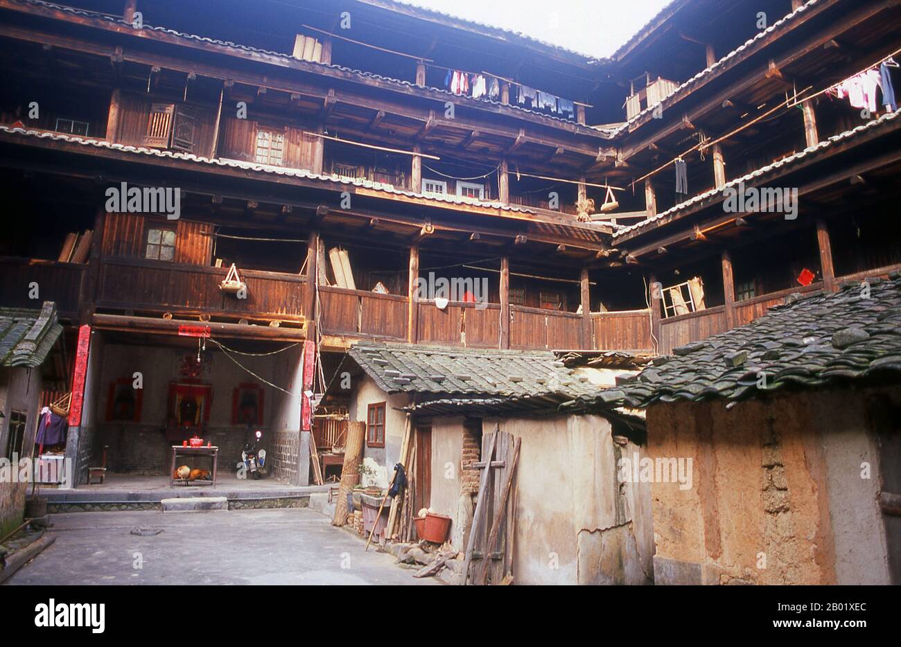 The Hakka (Kejia in Mandarin; literally 'guest people') are Han Chinese who speak the Hakka language. Their distinctive earthen houses or tulou can be found in the borderland counties where Guangdong, Jiangxi and Fujian provinces meet.  Communal entities, tulou are fortified against marauding bandits and generally made of compacted earth, bamboo, wood and stone. They contain many rooms on several storeys, so that several families can live together. The small, self-contained design is a common characteristic of Hakka dwellings (eg the Hakka walled villages at Kam Tin in Hong Kong’s New Territor Stock Photo