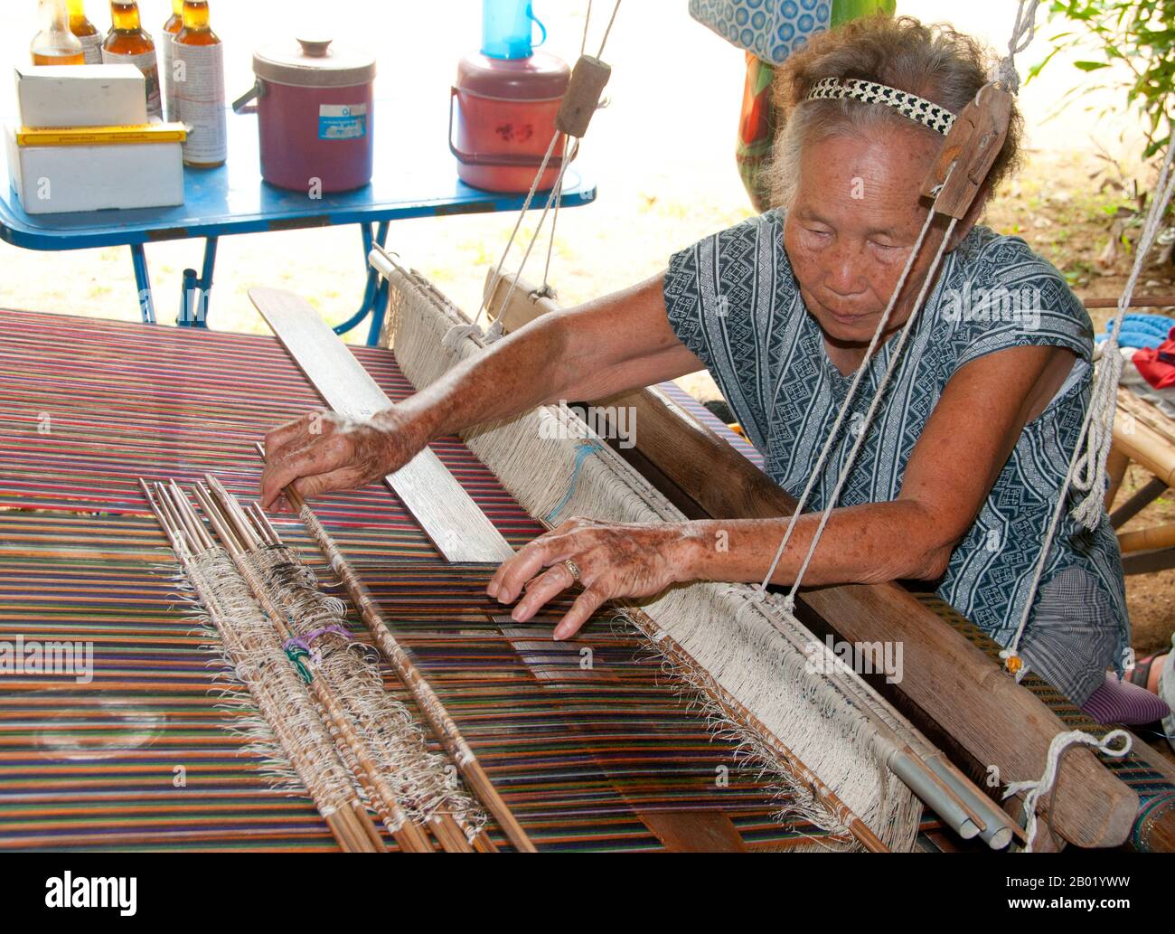 Thailand: Weavers in the Wiangyong district creating the famous Pha Mai Yok Dok silk fabrics, Lamphun, northern Thailand.  Pha Mai Yok Dok is an elaborately woven material in traditional method. Originally used in the northern royal court, it became popular during the reign of King Rama VI. The distinctive craftsmanship and skills in producing this type of silk have endeared it to those who prefer the traditional designs.  Lamphun was the capital of the small but culturally rich Mon Kingdom of Haripunchai from about 750 CE to the time of its conquest by King Mangrai (the founder of Chiang Mai) Stock Photo