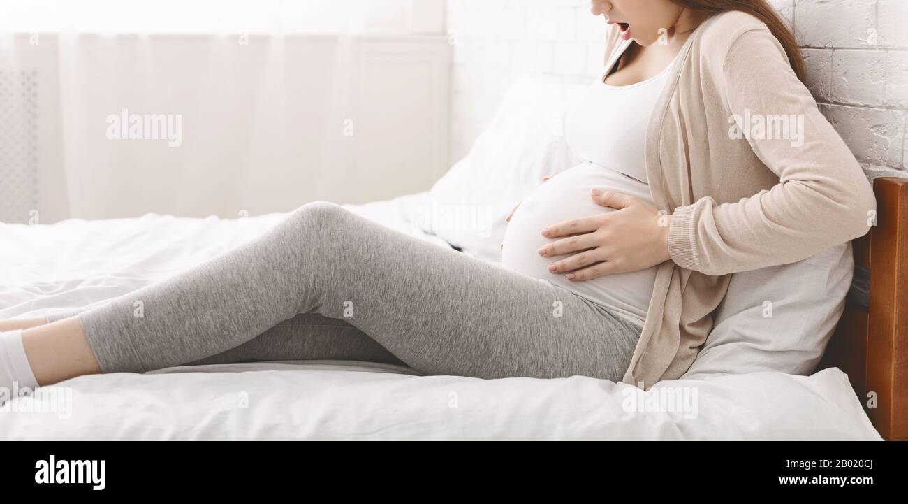 Pregnant woman suffering from contractions at home Stock Photo