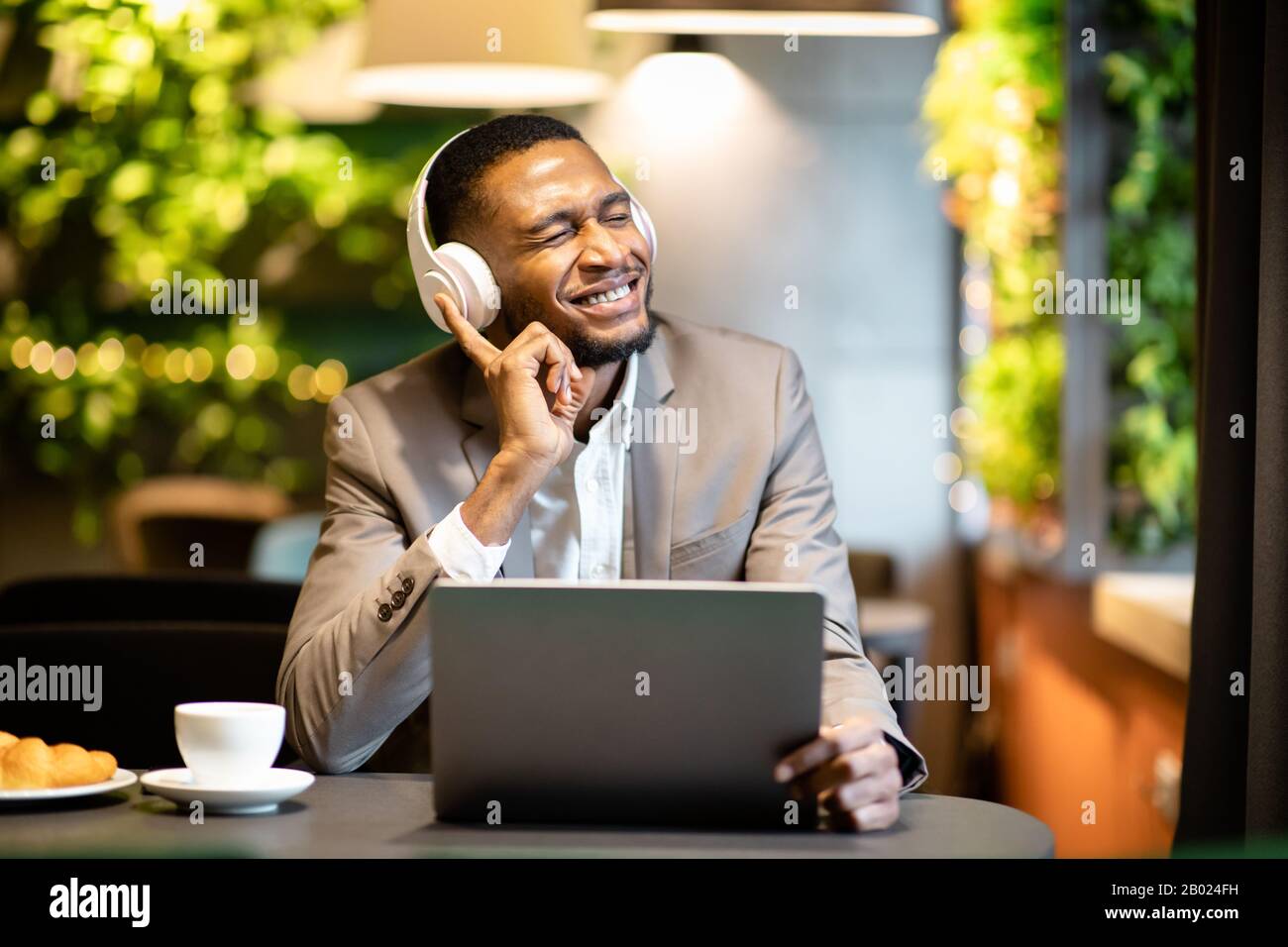 Young black businessman listening to music with headset Stock Photo - Alamy