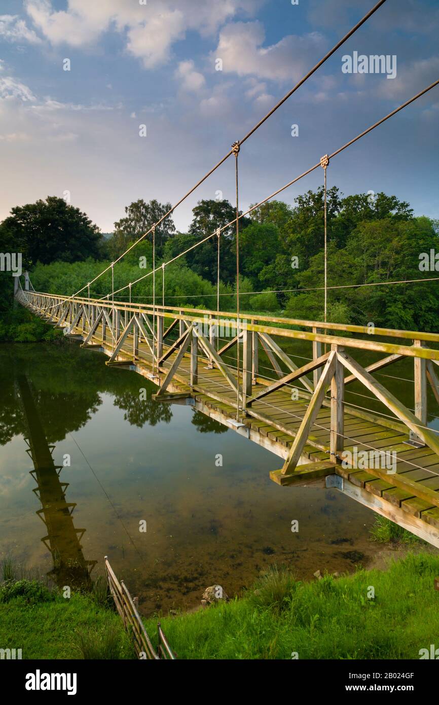 The suspension bridge over the River Teviot in the Scottish Borders for walkers on the Border's Abbey and Saint Cuthbert's Way long distance trails. Stock Photo