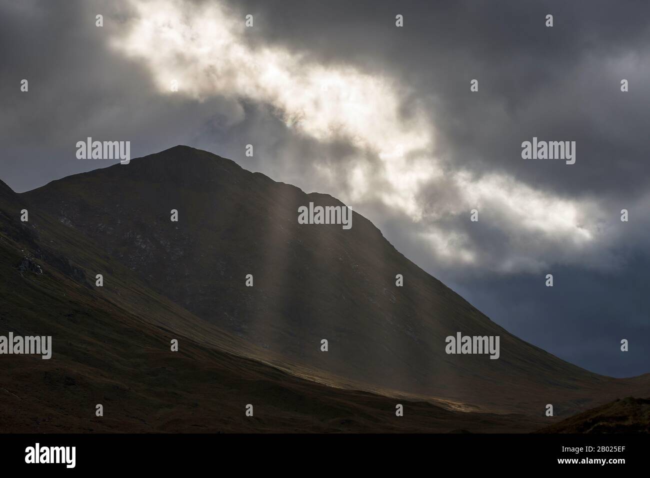 Shaft of light falling over Stob nan Cobar in the Scottish Highlands in the Pass of Glencoe, Scotland Stock Photo