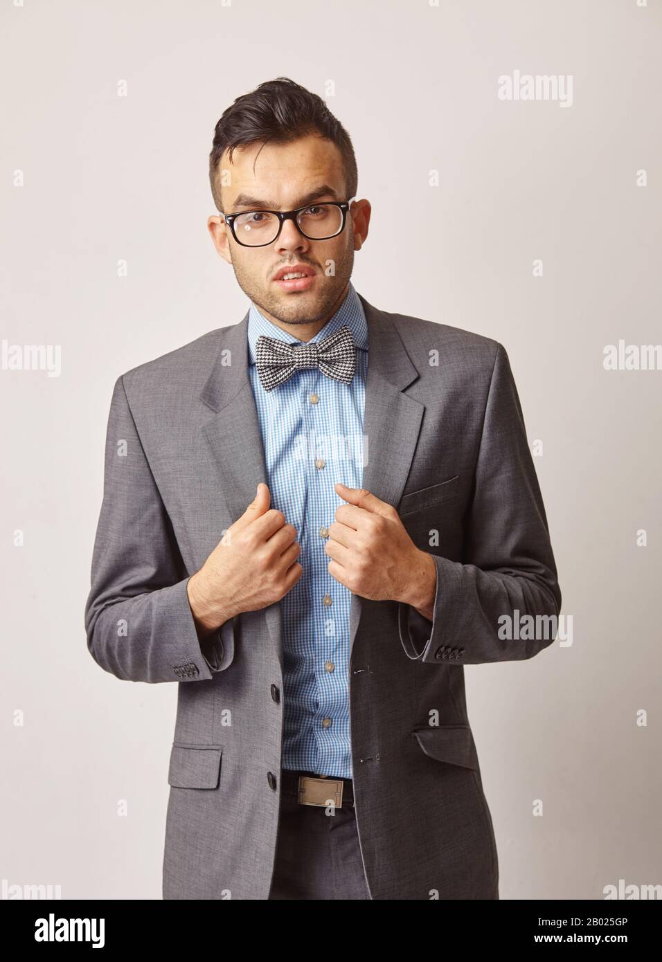 portrait of a young man in a blue shirt with a butterfly and glasses Stock Photo