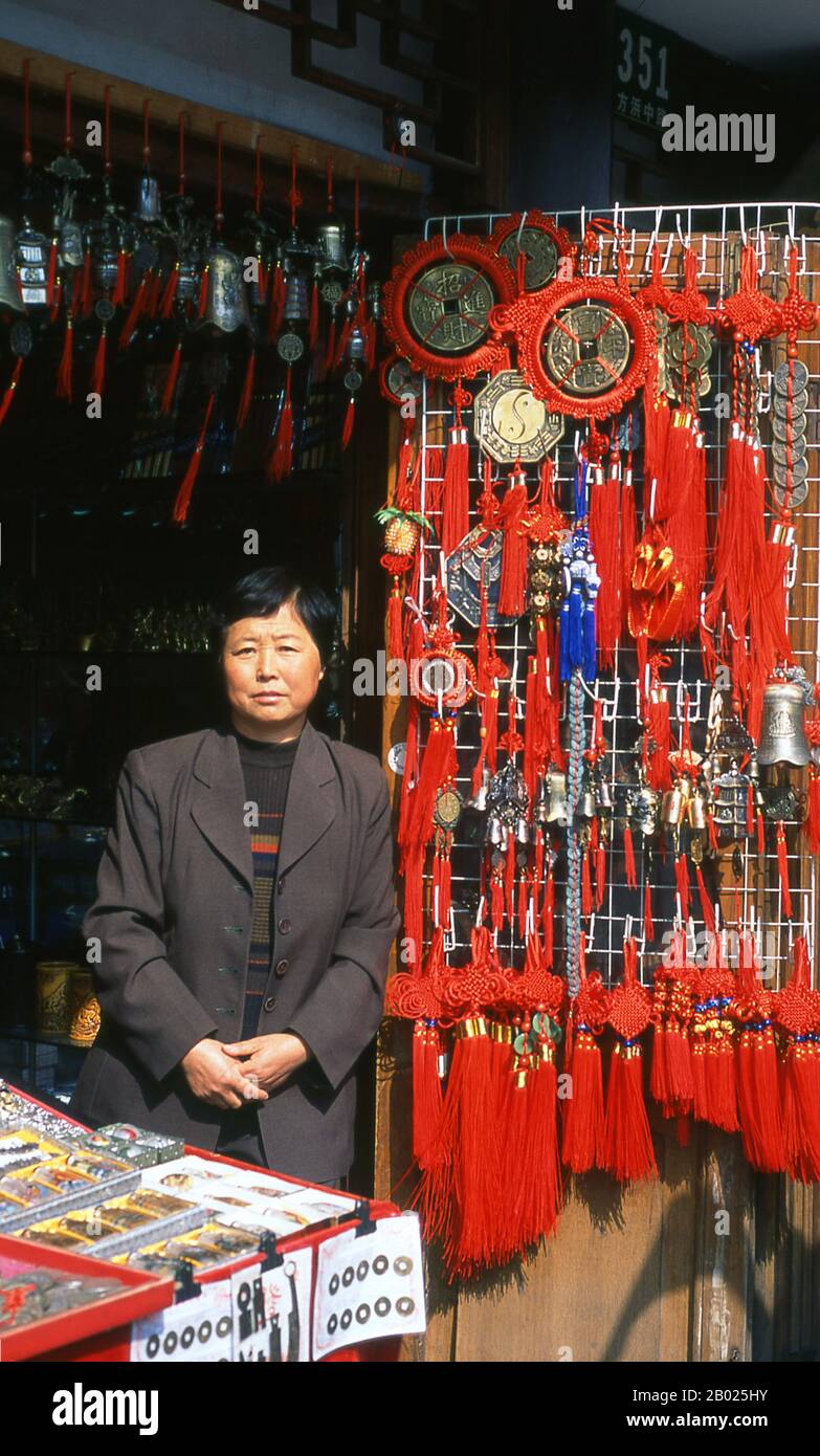China: Souvenir shop owner, Fangbang Lu, Nanshi or the Old Town area, Shanghai. Shanghai began life as a fishing village, and later as a port receiving goods carried down the Yangzi River. From 1842 onwards, in the aftermath of the first Opium War, the British opened a ‘concession’ in Shanghai where drug dealers and other traders could operate undisturbed. French, Italians, Germans, Americans and Japanese all followed. By the 1920s and 1930s, Shanghai was a boom town and an international byword for dissipation. Stock Photo