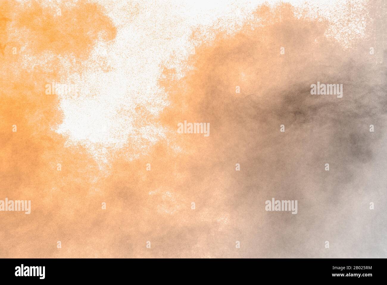 Brown dust explosion cloud.Brown particles splatter on white background. Stock Photo