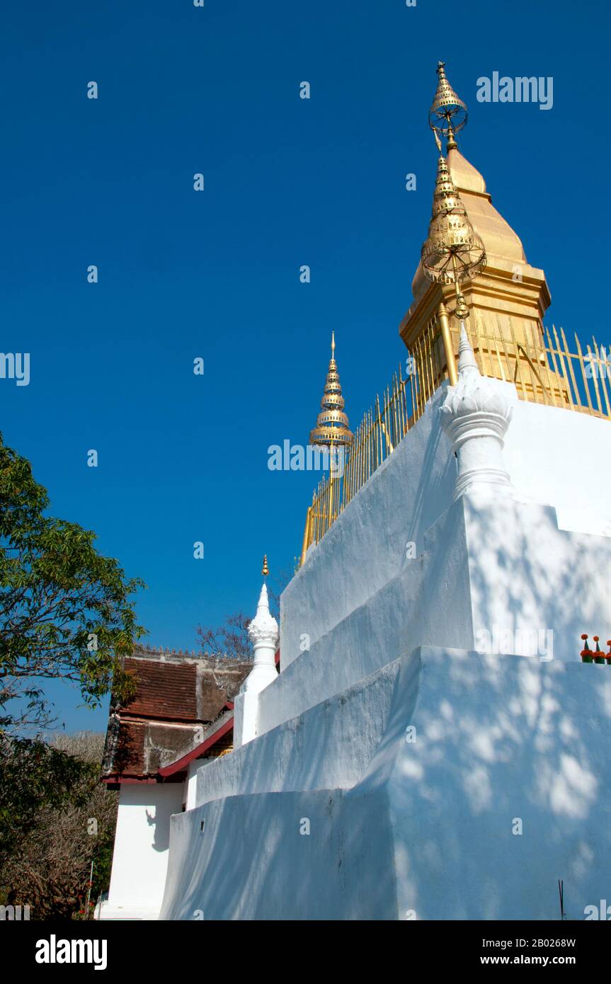 Laos: That Chomsi (Chomsi stupa) at the summit of Phousi (Phu Si) Hill, Luang Prabang. Phousi, a rocky 100-metre (330ft) hill, dominates the centre of Luang Prabang. At its foot stands Wat Paa Huak. From this temple 328 steps wind up to the 24-metre (79ft) That Chom Si on the summit, which has an impressive gilded stupa in classical Lao form.  Luang Prabang was formerly the capital of a kingdom of the same name. Until the communist takeover in 1975, it was the royal capital and seat of government of the Kingdom of Laos. The city is nowadays a UNESCO World Heritage Site. Stock Photo