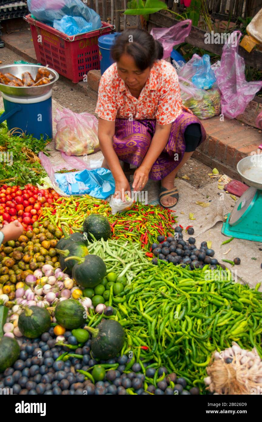 Laos: Fruit and vegetable vendor at the Morning market, Luang Prabang.  Luang Prabang was formerly the capital of a kingdom of the same name. Until the communist takeover in 1975, it was the royal capital and seat of government of the Kingdom of Laos. The city is nowadays a UNESCO World Heritage Site. Stock Photo