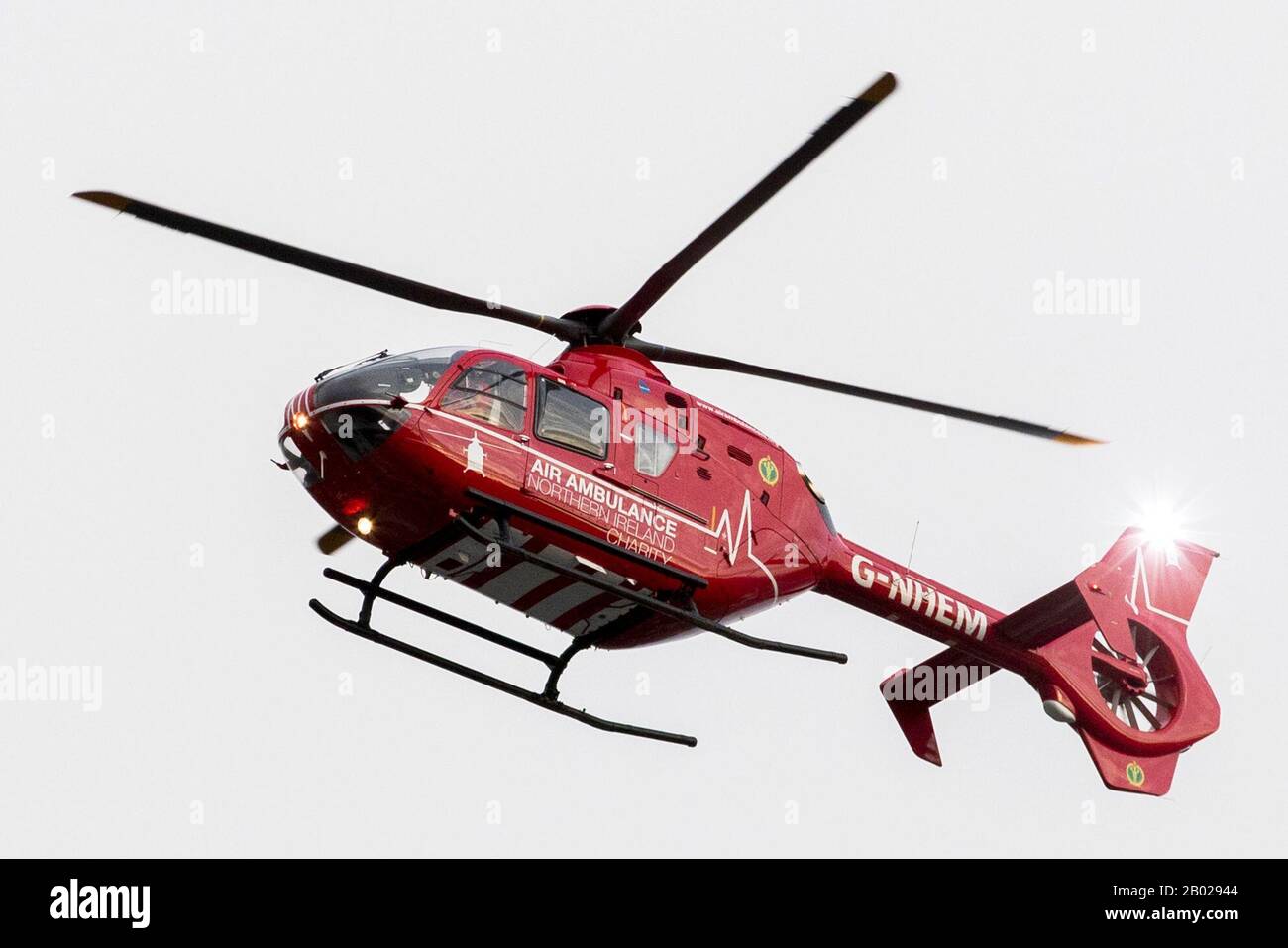 An air ambulance used by the Northern Ireland Helicopter Emergency Medical Service (HEMS) comes in to land on the helipad at the Royal Victoria Hospital in West Belfast, as the first test landing of an air ambulance took place on Tuesday at the West Belfast hospital. Stock Photo