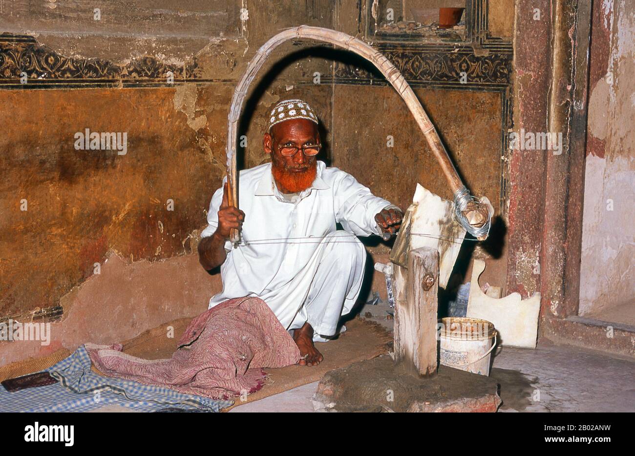 India: A marble craftsman at the tomb of I'timad-ud-Daulah, Agra.Etimad-ud-Daula's Tomb is a Mughal mausoleum in the city of Agra in the Indian state of Uttar Pradesh.  Along with the main building, the structure consists of outbuildings and gardens. The tomb, built between 1622 and 1628 represents a transition between the first phase of monumental Mughal architecture - primarily built from red sandstone with marble decorations, as in Humayun's Tomb in Delhi and Akbar's tomb in Sikandra - to its second phase, based on white marble and pietra dura inlay, elegantly realized in the Taj Mahal. Stock Photo