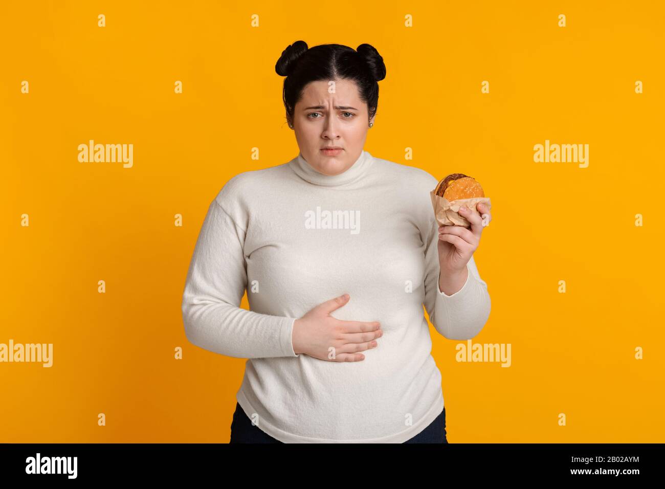 Stomachache. Girl Holding Burger And Touching Stomach Feeling Bad After