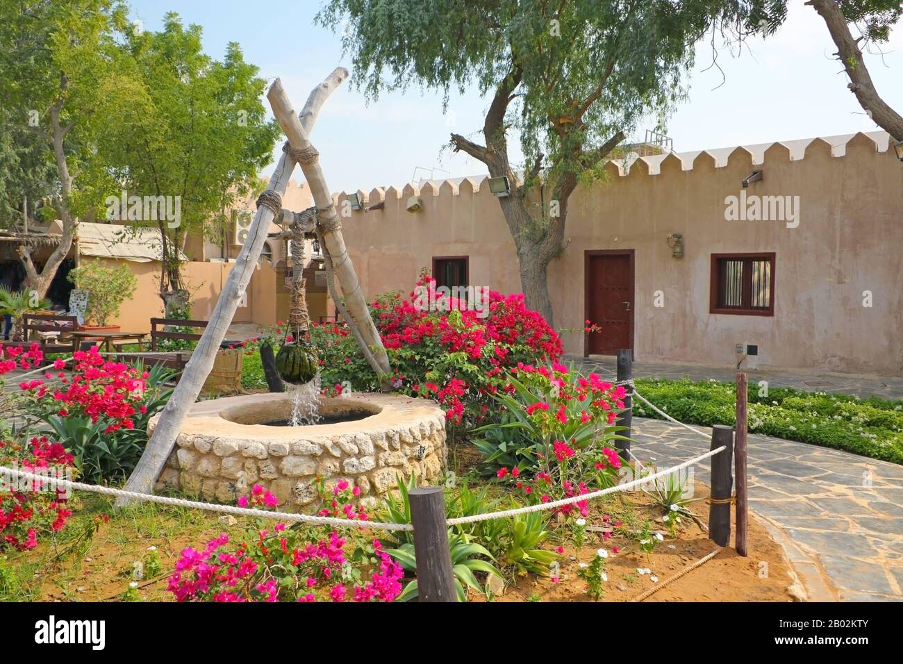 Traditional stone house and well in the front garden at the Heritage village, Abu Dhabi, United Arab Emirates. Stock Photo