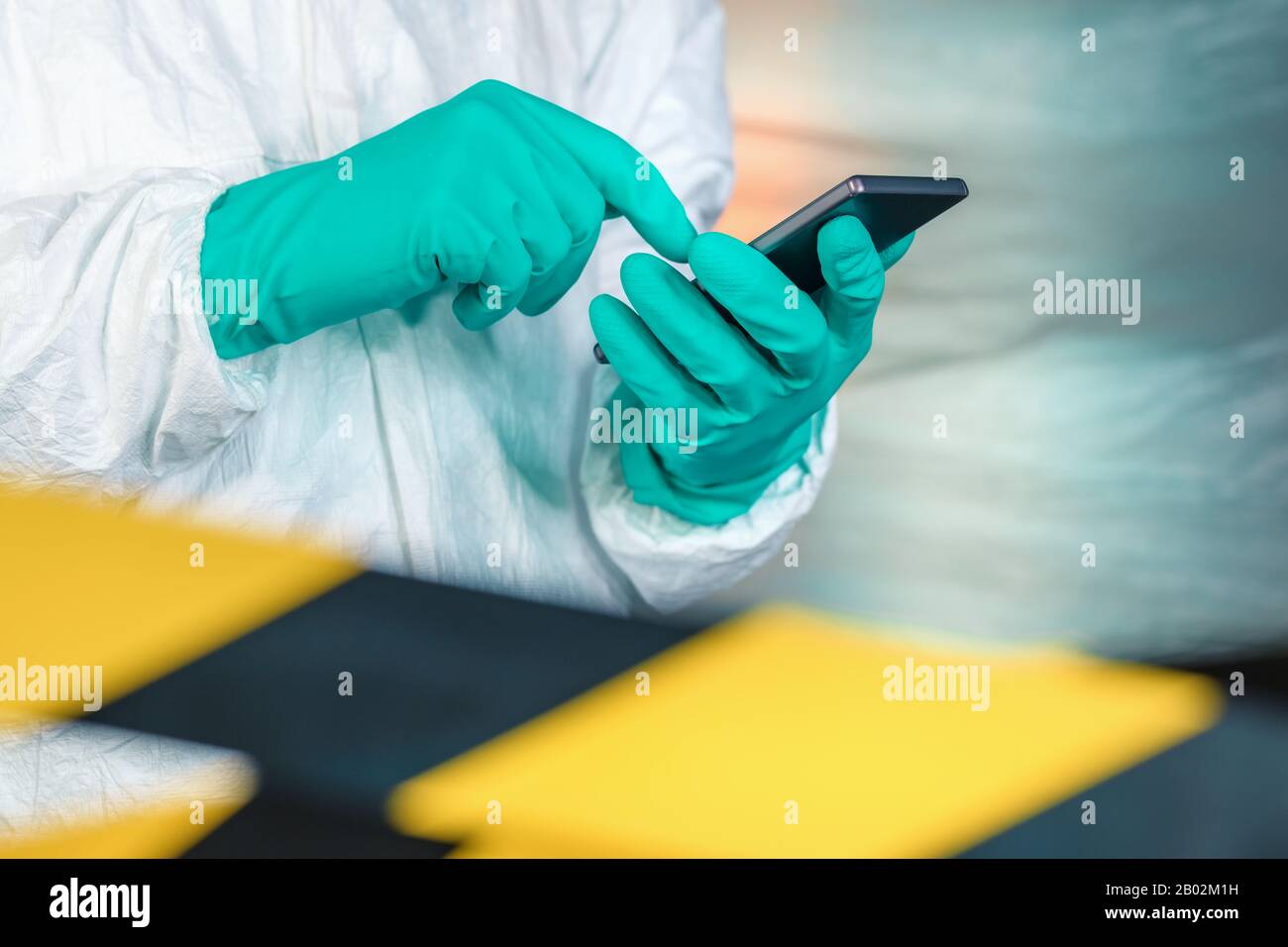 Epidemiologist using smartphone in Wuhan coronavirus quarantine, conceptual image with selective focus Stock Photo