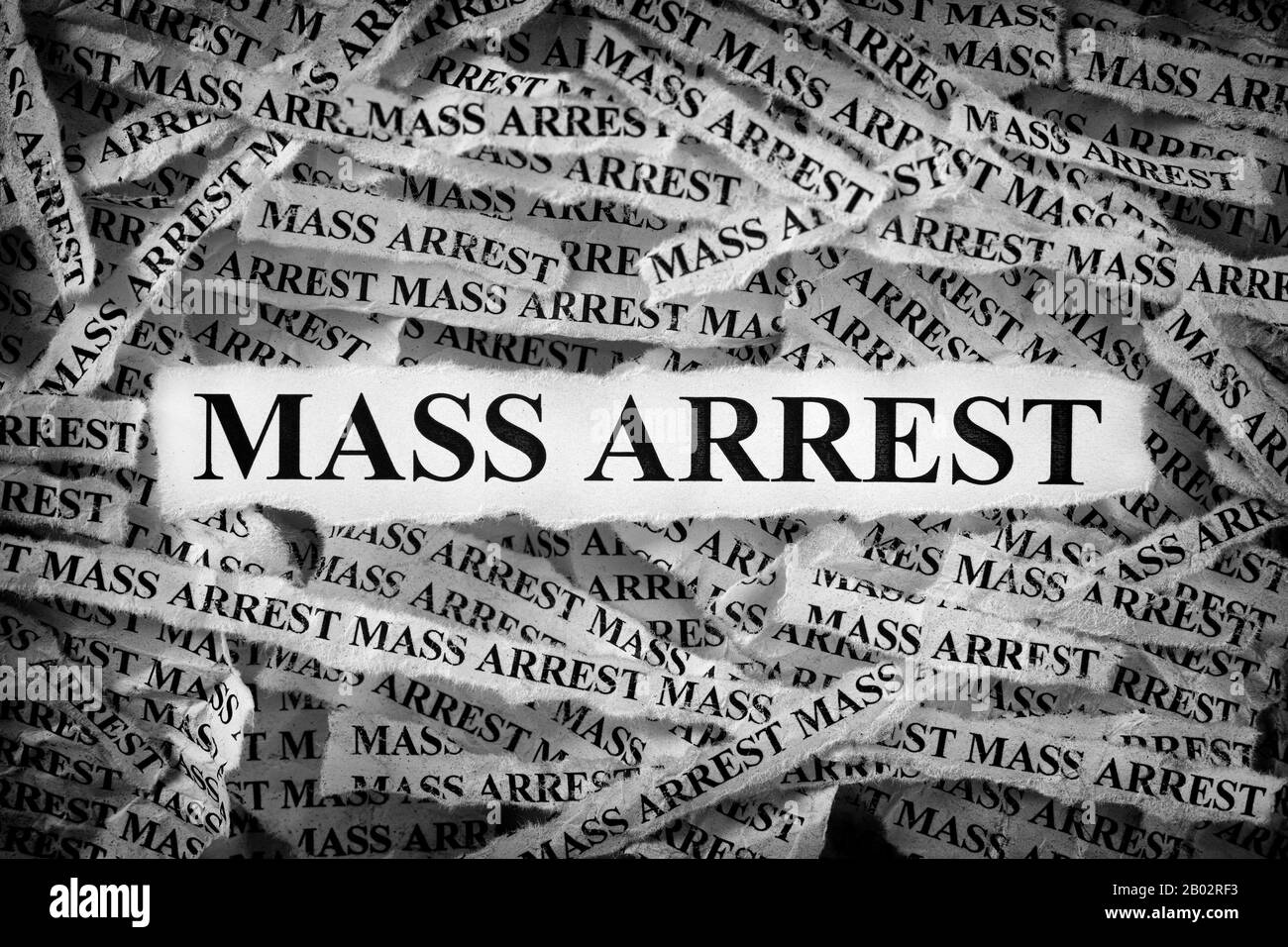 Strips of newspaper with the word Mass Arrest typed on them. Black and White. Close up. Stock Photo