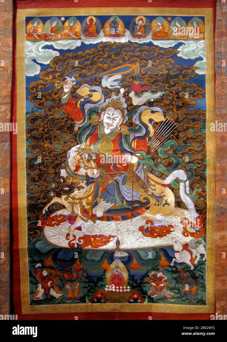 Mongolian Buddhism: Buddhist Thangka portraying a mountain deity wielding a sword. A 'thangka', also transliterated as 'tangka', 'thanka' or 'tanka' , is a Tibetan or Mongolian silk painting with embroidery, usually depicting a Buddhist deity, famous scene, or mandala. Stock Photo