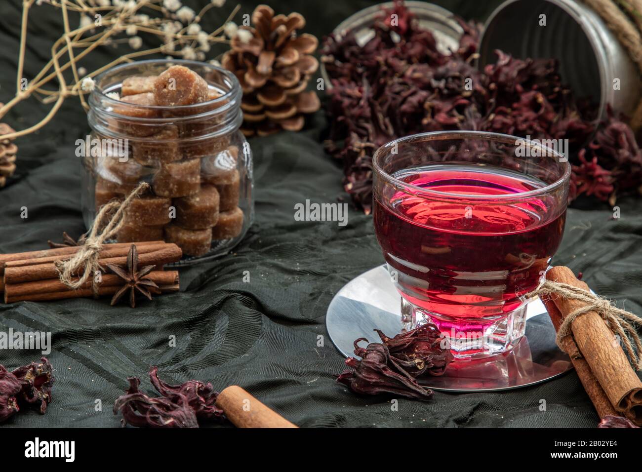 Roselle tea (Jamaica sorrel, Rozelle or hibiscus sabdariffa ) with dry roselle and brown cane sugar cube. Healthy herbal tea rich in vitamin C and min Stock Photo