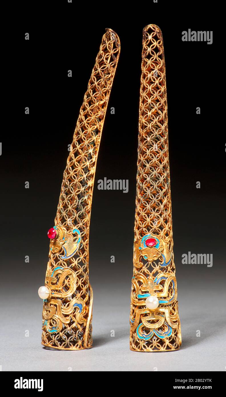Western descriptions of Chinese emperors, royalty and nobles often mention fingernails long enough to mark the person above any possibility of manual labor. These fingernail protectors, or guards, might be worn as a single jewel on the hand or in multiple sets.  According to the San Diego Museum of Art: 'Fingernail protectors were worn by a very elite group–Manchu court ladies of the late Qing dynasty. Although scholars of Chinese costumes usually date fingernail protectors to the Qing dynasty, they are in fact characteristic only of the late 19th century. Portraits of early Qing court ladies Stock Photo