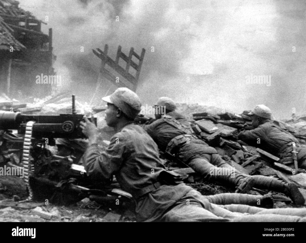 Chinese troops of the National Revolutionary Army fire on Japanese positions during the Battle of Changde, the strategic city in the heart of China’s rice-growing area. Although the Japanese army initially successfully captured the city, the Chinese 57th Division was able to pin them down long enough for reinforcements to arrive and encircle the Japanese. The Chinese Army then cut off the Japanese supply lines, forcing them into retreat. Changde, Hunan, Republic of China. November 1943. Stock Photo