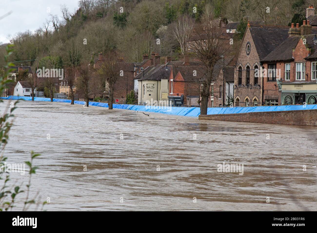 18th February 2020. The River Severn flooding in Ironbridge, Shropshire, England. A temporary flood barrier struggles to hold back the River, which has reached its highest point for 20 years, threatening homes and businesses along the River banks of the Ironbridge Gorge. The Ironbridge Gorge is a World Heritage Site. Stock Photo