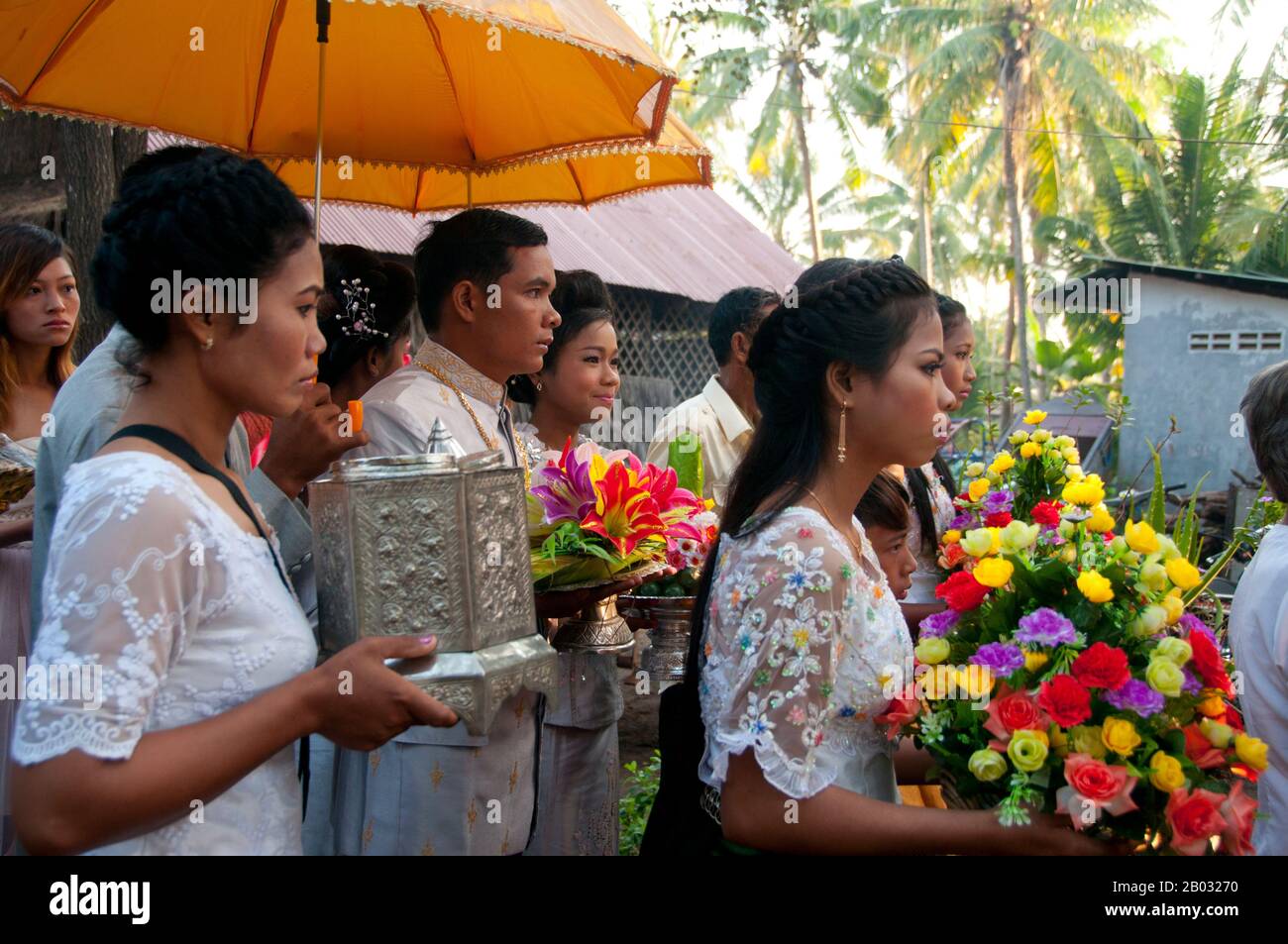 The traditional Khmer wedding is a long and colorful affair. Formerly it lasted three days, but since the 1980s it has more commonly lasted a day and a half.  The ceremony begins in the morning at the home of the bride and is directed by the achar (a specialist in ritual who acts as a master of ceremonies). Buddhist priests offer a short sermon and recite prayers of blessing. Parts of the ceremony involve ritual hair cutting and tying cotton threads soaked in holy water around the couple's wrists. Stock Photo