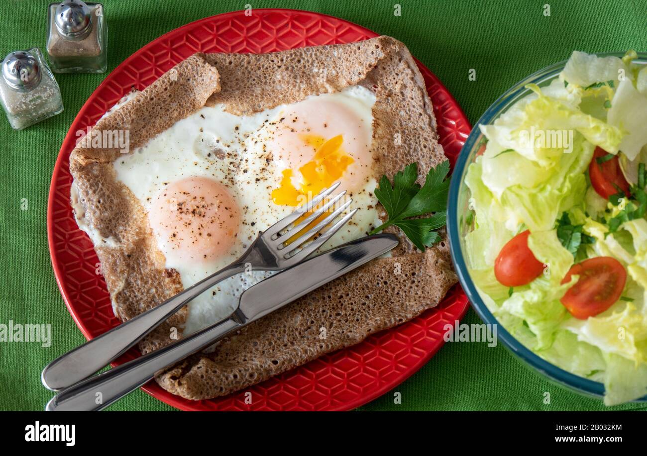 Breton crepe with egg in red plate Stock Photo