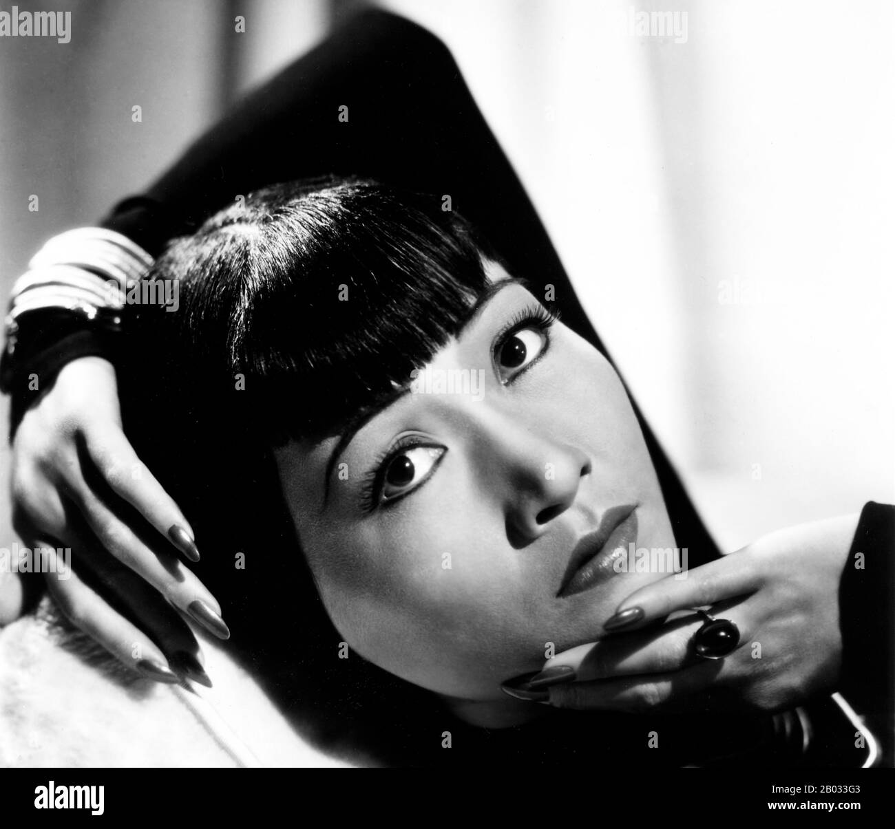 Anna May Wong (January 3, 1905 – February 3, 1961) was an American actress, the first Chinese American movie star, and the first Asian American to become an international star. Her long and varied career spanned both silent and sound film, television, stage, and radio.  Born near the Chinatown neighborhood of Los Angeles to second-generation Chinese-American parents, Wong became infatuated with the movies and began acting in films at an early age. During the silent film era, she acted in The Toll of the Sea (1922), one of the first movies made in color and Douglas Fairbanks' The Thief of Bagda Stock Photo