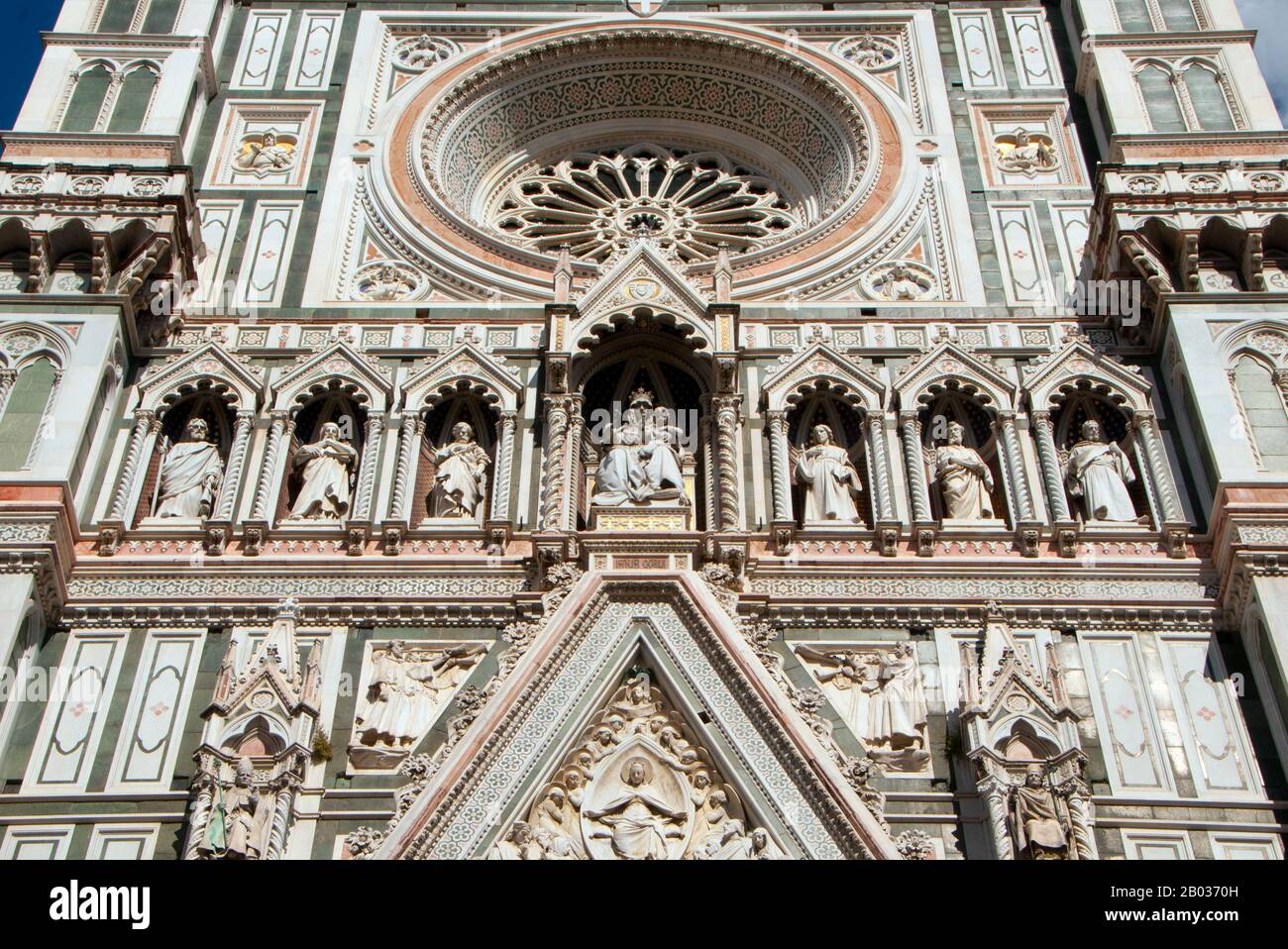 The Cattedrale di Santa Maria del Fiore (Cathedral of Saint Mary of the Flowers) is the main church of Florence. Il Duomo di Firenze, as it is ordinarily called, was begun in 1296 in the Gothic style with the design of Arnolfo di Cambio and completed structurally in 1436 with the dome engineered by Filippo Brunelleschi.  The exterior of the basilica is faced with polychrome marble panels in various shades of green and pink bordered by white and has an elaborate 19th-century Gothic Revival façade by Emilio De Fabris.  The cathedral complex, located in Piazza del Duomo, includes the Baptistery a Stock Photo