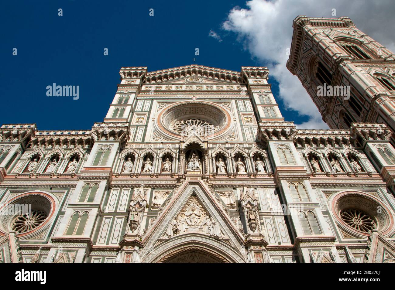 The Cattedrale di Santa Maria del Fiore (Cathedral of Saint Mary of the Flowers) is the main church of Florence. Il Duomo di Firenze, as it is ordinarily called, was begun in 1296 in the Gothic style with the design of Arnolfo di Cambio and completed structurally in 1436 with the dome engineered by Filippo Brunelleschi.  The exterior of the basilica is faced with polychrome marble panels in various shades of green and pink bordered by white and has an elaborate 19th-century Gothic Revival façade by Emilio De Fabris.  The cathedral complex, located in Piazza del Duomo, includes the Baptistery a Stock Photo