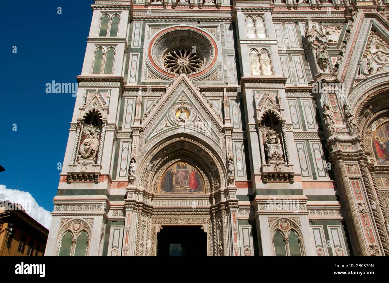 The Cattedrale di Santa Maria del Fiore (Cathedral of Saint Mary of the Flowers) is the main church of Florence. Il Duomo di Firenze, as it is ordinarily called, was begun in 1296 in the Gothic style with the design of Arnolfo di Cambio and completed structurally in 1436 with the dome engineered by Filippo Brunelleschi.  The exterior of the basilica is faced with polychrome marble panels in various shades of green and pink bordered by white and has an elaborate 19th-century Gothic Revival façade by Emilio De Fabris.  The cathedral complex, located in Piazza del Duomo, includes the Baptistery a Stock Photo