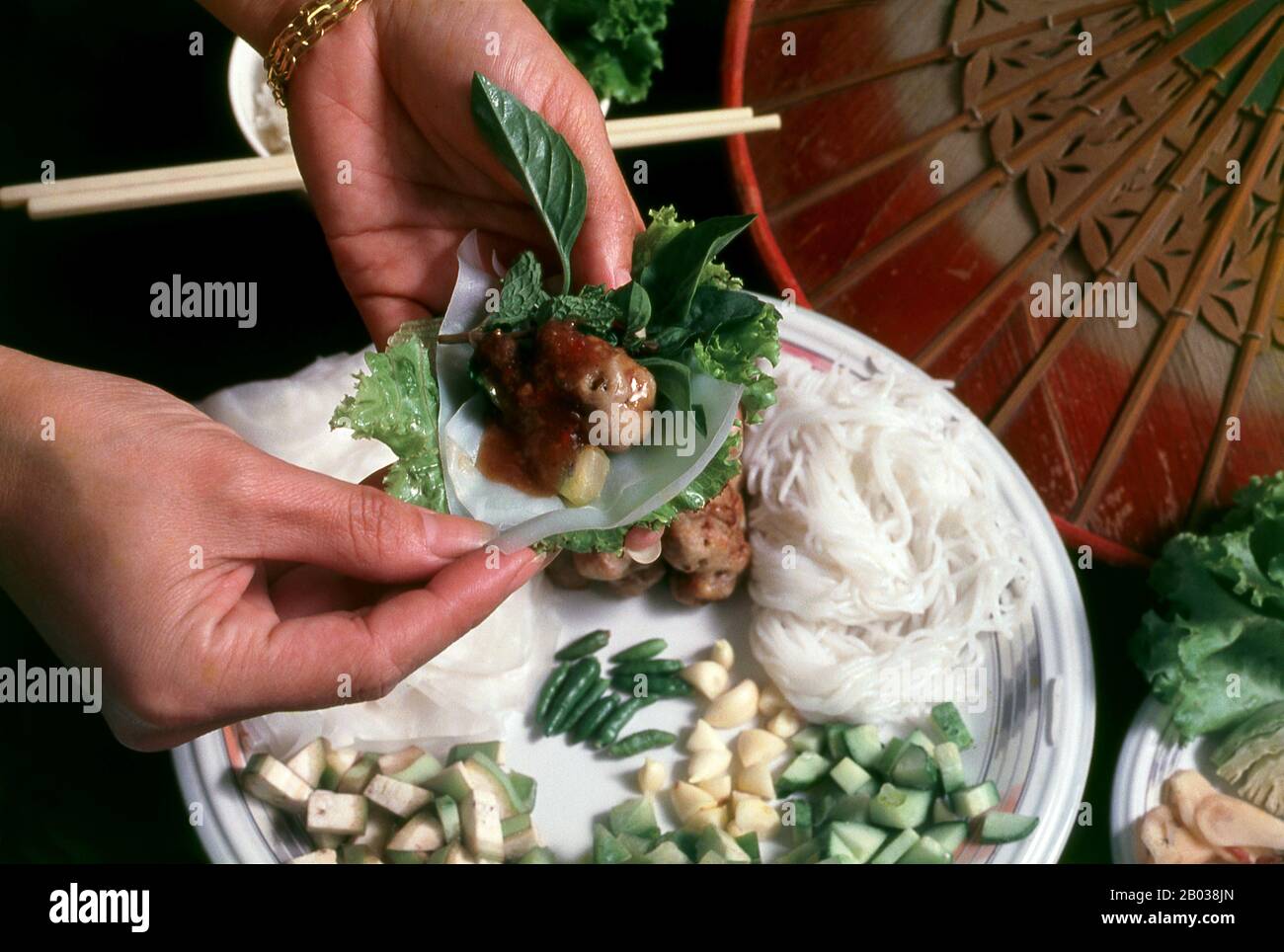 Nem nướng can be eaten alone as an appetizer or snack, and dipped in Nước chấm (dipping sauce), or with a peanut dip. Nước chấm is fish sauce diluted with water and flavored with sugar, lime juice, chopped raw garlic, chopped fresh bird's eye chili (Thai chili)/cayenne pepper, and sometimes with vinegar. The peanut sauce is made of peanut butter and hoisin sauce, flavored with fish sauce and crushed garlic, topped with crushed roasted peanut. It is served with fresh vegetables such as lettuce, julienned pickled vegetables like carrots and white radishes, and fresh herbs like mint and basil. Stock Photo