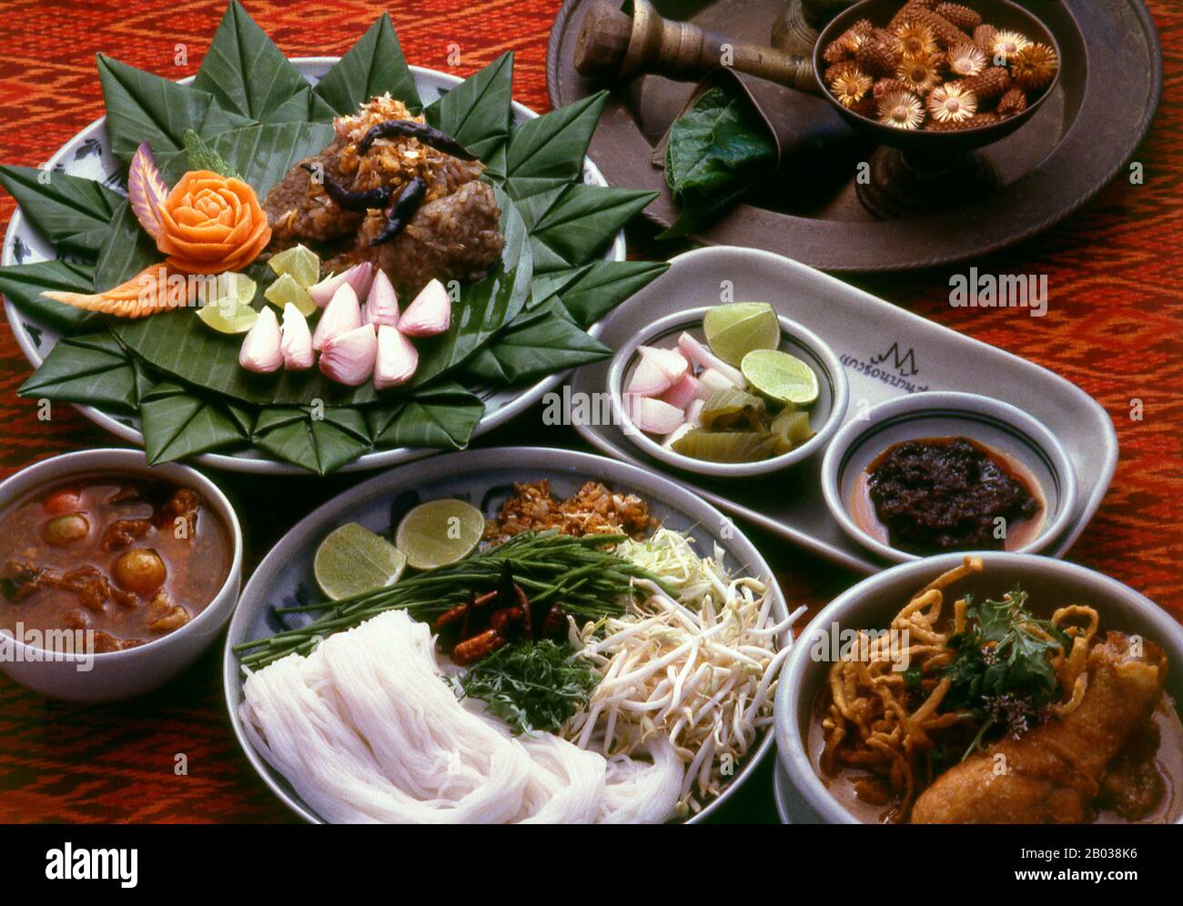The food of Northern Thailand, like the language, traditional dress and architecture, is quite distinct from that of Bangkok and central Thailand.  Northern Thai cuisine differs from central Thai cuisine in that it is clearly influenced by the traditions of neighbouring Burma, Laos and Yunnan. To begin with, the staple is not khao suai, the soft, fragrant boiled rice of the central plains so familiar to Westerners. Instead, the Khon Muang prefer to eat khao niaw, or glutinous sticky rice. This is steamed, served in tiny wicker baskets, and eaten with the fingers along with a selection of  spic Stock Photo