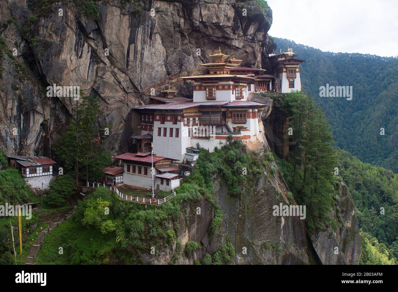 Paro Taktsang, also known by the names Taktsang Palphug Monastery and the Tiger's Nest, is a major Buddhist sacred site and temple complex built into the 1,000-metre (3,281-foot) cliffside of the upper Paro valley in Bhutan. Stock Photo